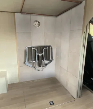 Receveur de douche invisible refermé par un plancher affleurant pour conserver un espace de vie dégagé dans le fourgon.