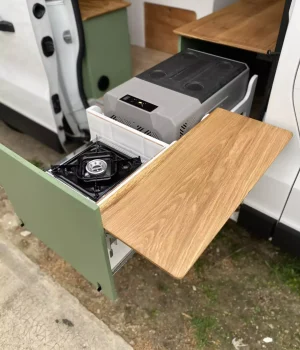 Tiroir cuisine coulissant avec réchaud à gaz, glacière et tablette escamotable dans un Renault Trafic aménagé l2H1.