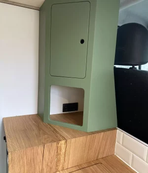 Meuble colonne avec niche de rangement et prises 230 V dans un aménagement de Renault Trafic.