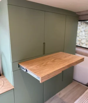 Table repas sur glissière en chêne intégrée au grand meuble de rangement d'un Renault Trafic L2H1 aménagé