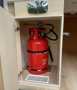 Coffre à gaz étanche avec bouteille GPL conforme intégré dans la soute d'un fourgon aménagé.