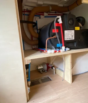 Compartiment technique avec chauffage, chauffe-eau, pompe à eau et vase d'expansion intégrés dans la soute.
